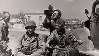 Fallschirmjäger und ein Kameramann einer Propagandakompanie nach der Landung auf Kreta 1941