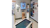 Bildtafeln und Fotos an einer Wand.