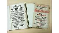 Titelseiten von zwei aufgeklappten Büchern über Artillerie