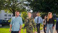 Junge Menschen gehen gemeinsam in einer Gruppe und informieren sich über die Ausbildungsmöglichkeiten bei der Bundeswehr