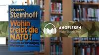 Im Vordergrund das blaue Buchcover mit weiß, orange und schwarzer Titelschrift, im Hintergrund unscharf ZMSBw Bibliothek.