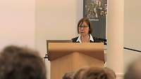 Frau Dr. Hochstetter spricht hinter einem Rednerpult