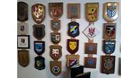 Wand mit vielen Wappen auf Holz