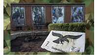 Gebäudeaußenwand mit Plakaten und Gedenkstein