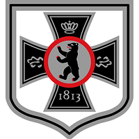 mittig Berliner Baer im runden silbernen Schild mit rotem Bord. Dieses ist auf das Eiserne Kreuz aufgelegt 