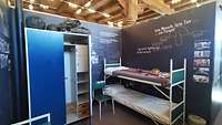 Stubeneinrichtung mit Doppelstockbett, Schrank und Stuhl