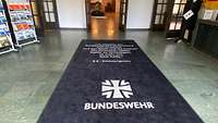 blauer Teppich mit weißer Schrift mit Eid der deutschen Soldatinnen und Soldaten 