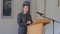 Soldat in Generalsuniform steht am Rednerpult und spricht ins Mikrofon