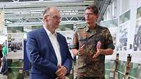 ein Soldat und ein Mann im Anzug im Gespräch