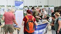 Viele Menschen stehen an einem Messestand