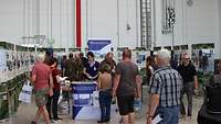 Viele Menschen an einem Messestand