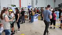 Viele Menschen in einer Halle mit Ausstellungsgegenständen