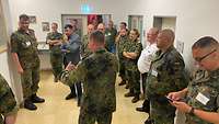 Mehrere Soldaten stehen im Flur und hören einem Vortragenden zu
