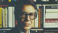 Porträt Rainer Wohlfeil vor Bücherregel