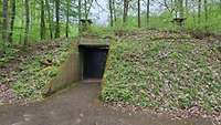 Außenansicht eines verbunkerten Munitionslagerhauses im Wald