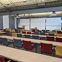 Tagungsraum mit mehreren bestuhlten Tischreihen