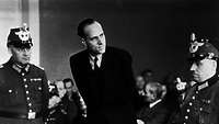 Helmuth James Graf von Moltke steht zwischen zwei Polizisten während des Prozesses am Volksgerichtshof im Januar 1945.
