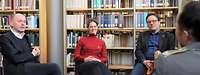 Gruppe aus zwei Wissenschaftlern und einer Wissenschaftlerin im Interview mit Offizier sitzend.