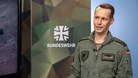 Zwei Soldaten stehen sich an einem Tisch gegenüber und sprechen miteinander