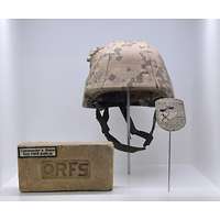 Gefechtshelm mit Helmbezug in Wüstenflecktarn davor ein Ziegelstein mit eingeprägtem Schriftzug