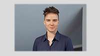 Passbild einer jungen Frau vor einem neutralen Hintergrund