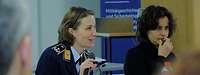 eine junge Frau in Uniform am Mikrofon