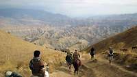 Blick auf die Landschaft Nordafghanistans und Männers zu Fuß und auf Pferden