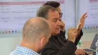 Ein Foto von Männern, die miteinander diskutieren und einander zuhören.